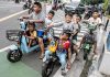 Sejumlah anak-anak menggunakan sepeda listrik di jalan raya.