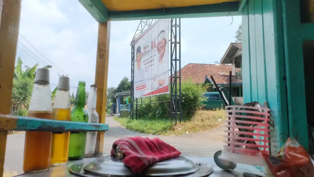 Gerobak mie ayam dan baliho salah satu bakal calon Bupati Purwakarta di satu persimpangan jalan di Desa Babakan Kecamatan Wanayasa Kabupaten Purwakarta (Foto: Jabarnews.com)