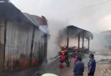 Pemadam Kebakaran berupaya memadamkan api yang membakar pasar