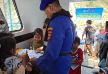 Personel Satpolairud Polres Purwakarta saat ajarkan anak membaca. (Foto: Dok Polres Purwakarta)