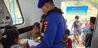 Personel Satpolairud Polres Purwakarta saat ajarkan anak membaca. (Foto: Dok Polres Purwakarta)