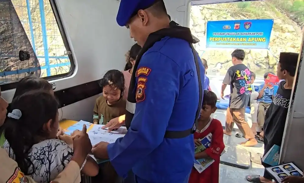 Personel Satpolairud Polres Purwakarta saat ajarkan anak membaca. (Foto: Dok Polres Purwakarta)