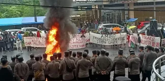 Massa dari berbagai elemen masyarakat melakukan aksi unjuk rasa menolak rapat pleno penetapan pemenang pilkada oleh KPU Kota Tasikmalaya di depan Hotel Grand Metro Tasikmalaya (Foto: Kompas)