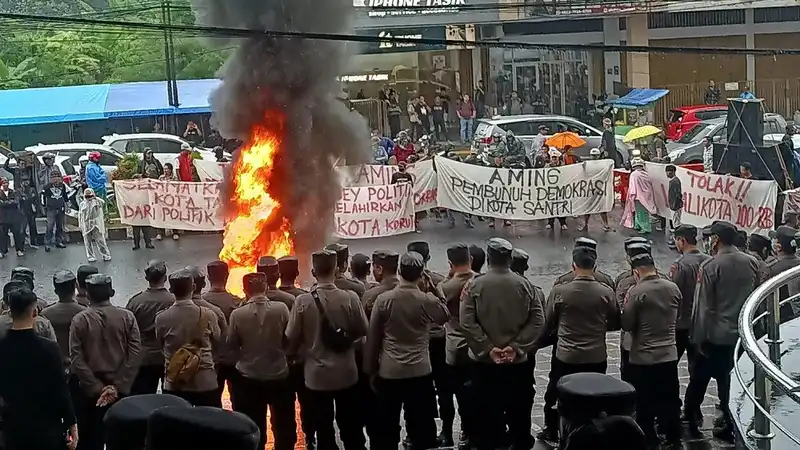 Massa dari berbagai elemen masyarakat melakukan aksi unjuk rasa menolak rapat pleno penetapan pemenang pilkada oleh KPU Kota Tasikmalaya di depan Hotel Grand Metro Tasikmalaya (Foto: Kompas)