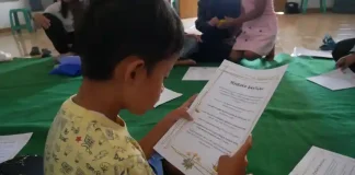 Seorang anak di Dago Elos Bandung me-review bahan bacaan, sebagai salah satu kegiatan TuturKami dalam meningkatkan literasi. (Foto: Ist)