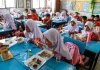 Para siswa menikmati menu yang disajikan dalam program makan bergizi gratis