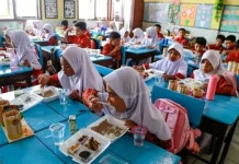 Para siswa menikmati menu yang disajikan dalam program makan bergizi gratis