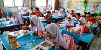 Para siswa menikmati menu yang disajikan dalam program makan bergizi gratis