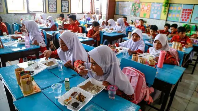 Para siswa menikmati menu yang disajikan dalam program makan bergizi gratis